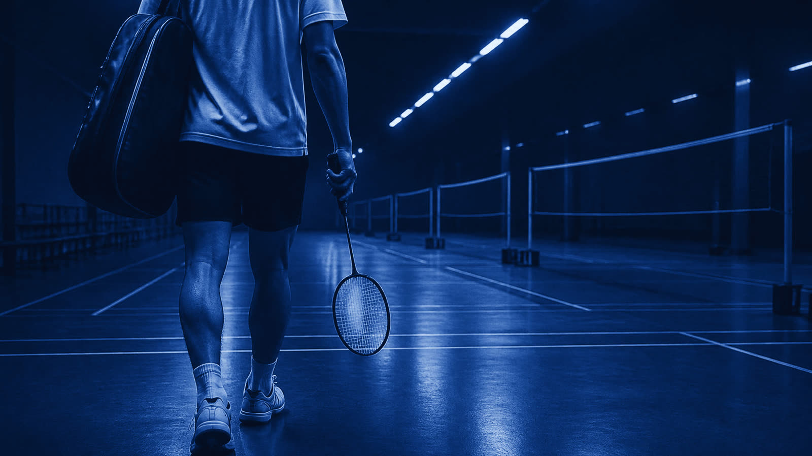 A player walking onto an empty court at night
